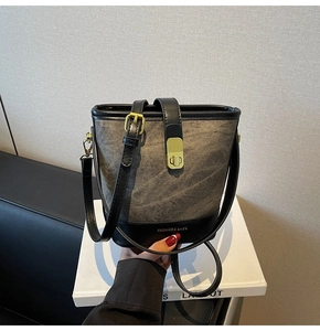 Detailed close-up of fashion bucket bag with grey fabric texture and gold lock clasp