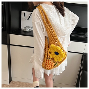 Close-up of yellow crochet tote bag featuring a large sunflower and hollow knit texture