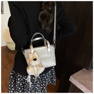 Detail of silver glitter handbag with wave texture and cute white plush bear charm