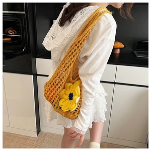 Detail of yellow hollow knit bag featuring a large sunflower applique and woven mesh