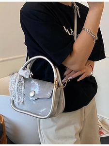 Silver leather crossbody square bag with lace bow and metal buckle shown by model