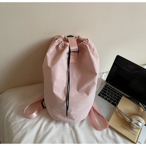 Pink drawstring bucket bag detail with lightweight nylon fabric and versatile straps