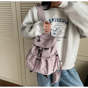 Dettaglio dello zaino in nylon lavanda con chiusura a coulisse e tessuto increspato