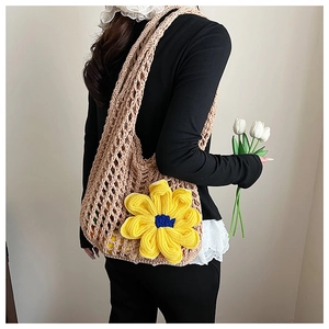 Detail of hand-crocheted khaki mesh shoulder bag featuring a large yellow sunflower decor