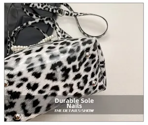 Detail view of leopard print crossbody bag with silver wear-resistant studs and glossy finish