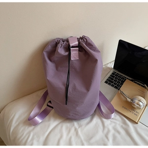 Macro detail of purple drawstring backpack with nylon texture on white fabric backdrop