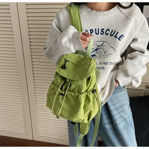 Dettaglio dello zaino in nylon verde lime con chiusura a coulisse e tasche laterali