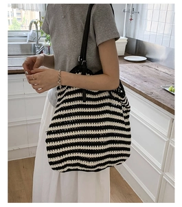 Detail of black and white striped crochet shoulder bag with adjustable leather strap