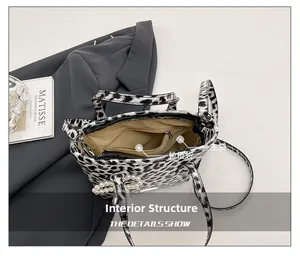 Interior view showing zippered pocket and pearl charm of the leopard print crossbody bag