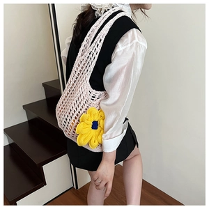 Detail of hand-knitted crochet mesh tote bag with a yellow sunflower on pink floral bag