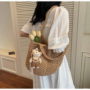 Detailed close-up of brown crochet tote bag with a teddy bear charm and tulips
