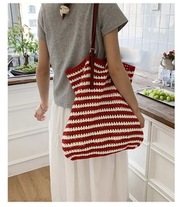Detail of red and white striped crochet tote bag with adjustable leather shoulder strap