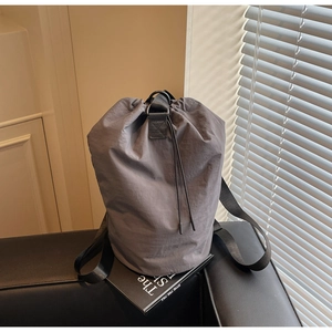 Detail of grey drawstring bucket bag made of durable nylon on a stylish interior background