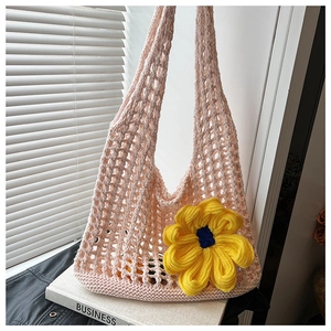 Detail of pink knitted tote bag with a large yellow sunflower and hollow mesh texture