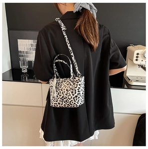 Detailed look at leopard print crossbody bag with pearl bow charm and shoulder strap