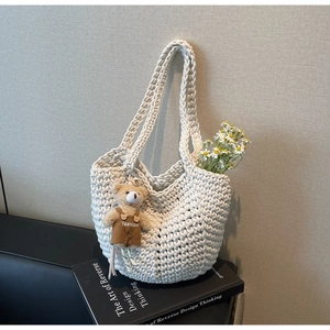 Detailed view of woven texture on cream tote bag with cute bear charm accessory