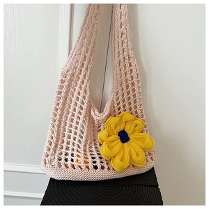Close-up of pink crochet tote bag with detailed hollow mesh and yellow floral accent