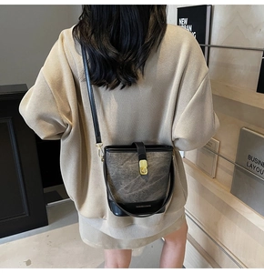 Detail view of vintage bucket bag featuring distressed gray fabric and gold buckle hardware