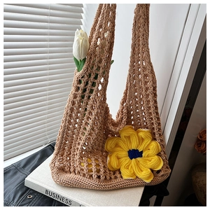 Detailed texture of khaki crochet knit beach tote featuring a yellow sunflower charm