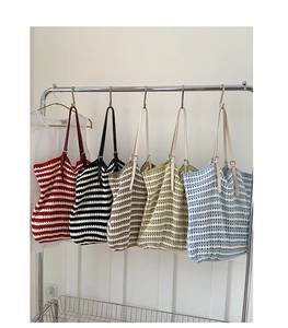 Detail of multi-color striped knitted tote bags with adjustable leather straps on hangers