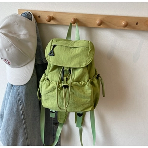 Dettaglio dello zaino in nylon verde chiaro con chiusura a coulisse e tasca a patta