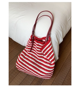 Detail of red and white striped crochet tote bag with dark red leather adjustable strap