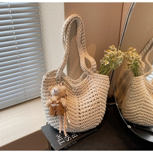 Close-up of beige chunky cotton rope woven bag with a cute teddy bear doll charm