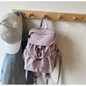 Detail of lavender nylon backpack with drawstring closure and flip cover design