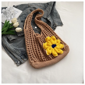Detail of hand-woven mesh tote bag with a yellow sunflower on white fabric background