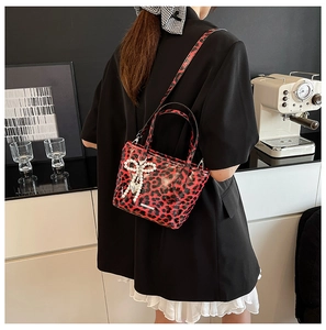 Chic red and black leopard print crossbody bag with pearl bow and heart charm detail
