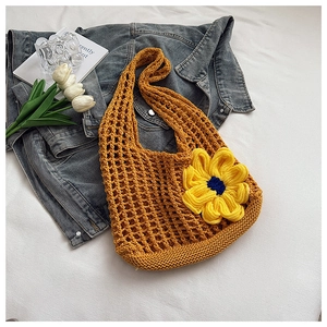 Detail of yellow crochet hollow tote bag featuring a large 3D floral knit decoration