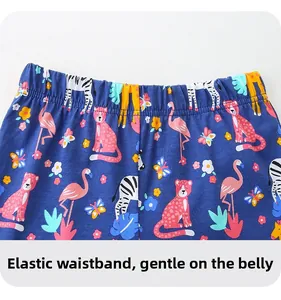 Detail of elastic waistband on navy cotton kids trousers with colorful animal print