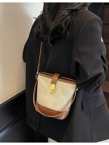 Chic two-tone canvas bucket bag with brown leather trim and golden metal lock