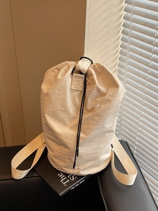Minimalist beige nylon drawstring bucket bag with adjustable straps for casual daily use