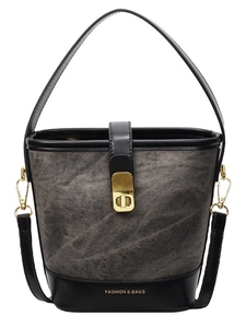 Retro grey denim bucket bag with black leather trim and golden metal clasp on white background