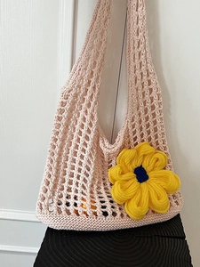 Pink crochet hollow knit beach bag with a large yellow sunflower and internal fruit contents