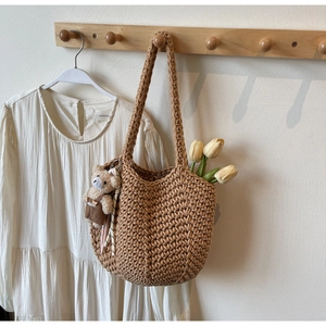 Macro detail of hand-woven crochet bucket bag texture with a cute plush bear charm