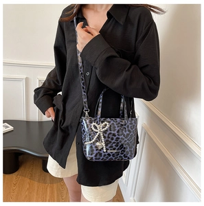 Glossy purple leopard print tote bag with pearl bow and metal heart charm detail
