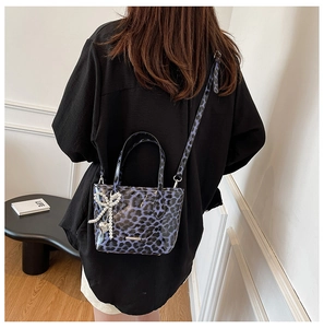 Detail of purple leopard print patent leather bag with pearls and silver heart charm