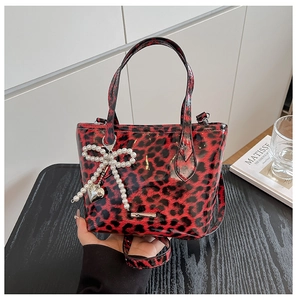 Detail of red and black leopard print crossbody bag with pearl bow and heart charm