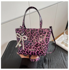 Macro detail of purple leopard print handbag with glossy finish and pearl bow charm