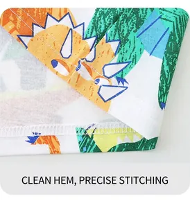 Détail de l'ourlet à double couture et de l'imprimé dinosaure coloré sur t-shirt coton