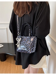 Purple leopard print crossbody bag with pearl bow charm and adjustable strap