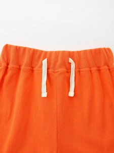 Boys orange cotton knit sports shorts with elastic waistband and white flat drawstrings