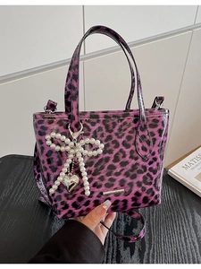 Chic purple leopard print tote bag in glossy patent leather with pearl bow charm detail