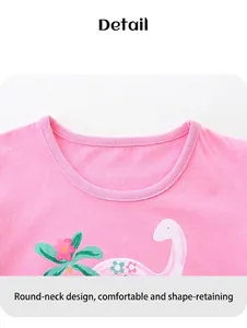 Détail d'un t-shirt en coton rose avec imprimé dinosaure mignon et col rond côtelé