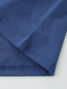 Cuciture dettagliate di una t-shirt blu in cotone per bambini con doppia cucitura piatta