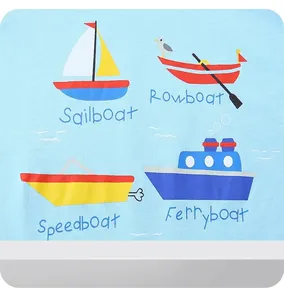 Detail of light blue boys' cotton T-shirt featuring colorful cartoon sailboat prints