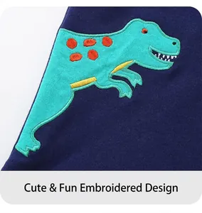 Gros plan d'une broderie dinosaure vert sur un short en maille bleu marine aux détails fins