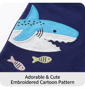 Close-up of knit fabric featuring colorful embroidered cartoon shark and fish details